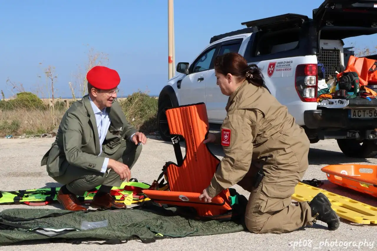 A volunteer prepares a rescue extrication device with the visiting guest